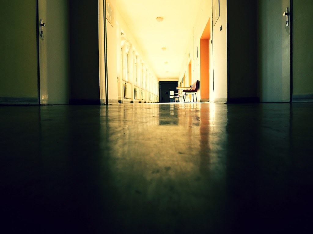 Empty hospital corridor at a quiet hour, seen low along a polished floor