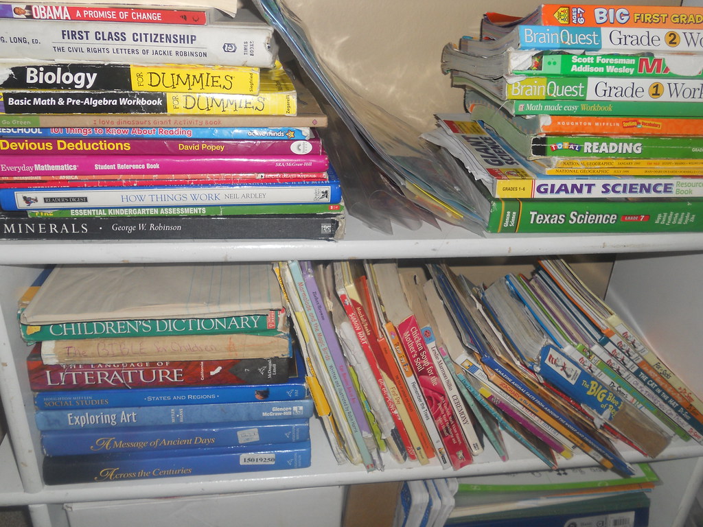 A stack of textbooks and study material on a desk